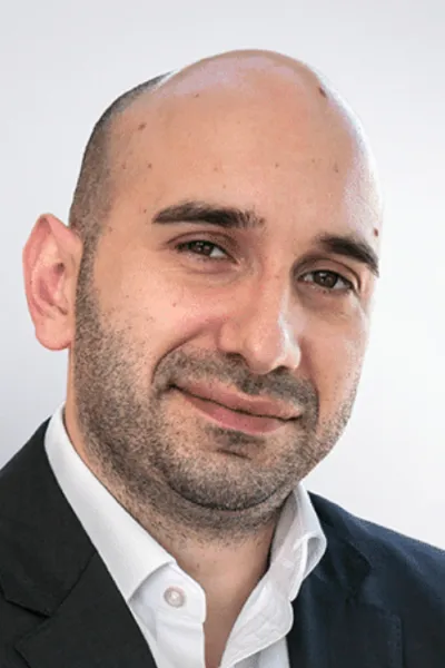 A portrait photo of a SIXT employee in a suit.