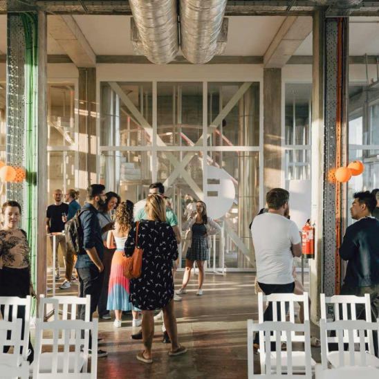 SIXT office in Portugal with employees networking in a modern, open-concept workspace flooded with natural light.