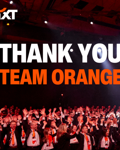 A big group of people wearing SIXT uniforms, laughing and throwing their hands in the air. The image features the phrase: "Thank you, Team Orange!".